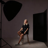 The Black side of the PIxapro 1x2m Foldable Black/white V-Flat Panel being used as negative fill with a model