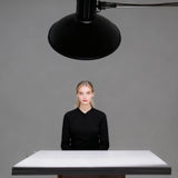 The PIxapro 1x2m Foldable Black/white V-Flat Panel being used as a make-shift posing table to bounce light underneath  a model's chin