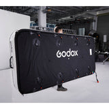 Gaffer carrying a Godox KNOWLED AM1600R-48K 4'x8' Inflatable RGB LED Light Mat showing the back of  the panel