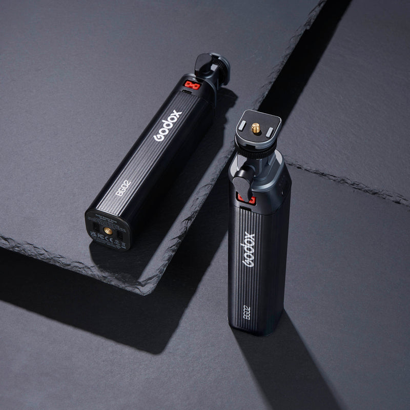 Two Godox BG02 Battery Grips on a dark slate backdrop