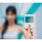 A hand holding a Godox C100 Transparent Viewfinder Camera, with a blurred person in the background against a teal and white backdrop.