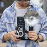 Godox FB01 Camera Mount Flash Bracket with a LUX Master flash and an old twin-lens reflex camera mounted to it being held by a photographer
