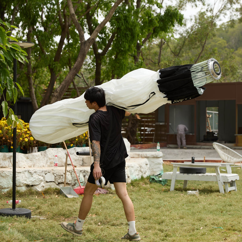 GODOX KNOLED GL7 7-Foot G-Mount Lantern Diffuser being  carried by a member of the film crew in its collapsed state