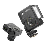 Two Godox Lux Junior II flashes shown on a clean white background, one in a wider side view and one in a closer front/top view.