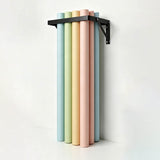 The PiXAPRO Wall-Mounted 12 Seamless Paper Backdrop Roll Storage Rack being used to hold a selection of seamless paper backdrop rolls
