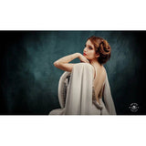 A woman sitting astride a chair in an elegant white dress in front of a 3x2m Abstract Texture Fine Art Green tones Horizontal Background from Kate Backdrops