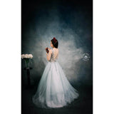 A Woman in a white evening gown holding flowers against a 3x2m Abstract Texture Fine Art Green tones Horizontal Background from Kate Backdrops