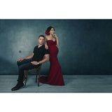 A man sitting on a chair next to a woman in a red dress against a 2x3 Cold Tones Of Grey And Little Green Light Abstract Textured Studio Photography Background From Kate Backdrops