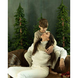 A Lady and a young boy sitting on a brown leather sofa in front of a Abstract Olive Green Textured Studio Photography Backdrop