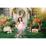 A young girl in bunny ears, standing in front of an Easter House Bunny Garden Carrots Backdrop with Easter decorations.