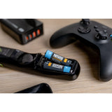 Two Newell USB-C Rechargeable  batteries, being used in a remote control on table with other electronic devices 