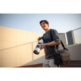 SAKK GEAR Laptop Camera Sling Photographer with big camera on location with bag over their shoulder