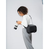 SAKK GEAR 9L Camera Sling Photographer looking at camera with bag over their shoulder