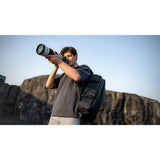 SAKK GEAR 28L Backpack Photography Holding Camera with Backpack over Shoulder