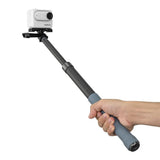 Hand holding a Telesin carbon fibre selfie stick with an Insta360 GO 3 camera mounted.